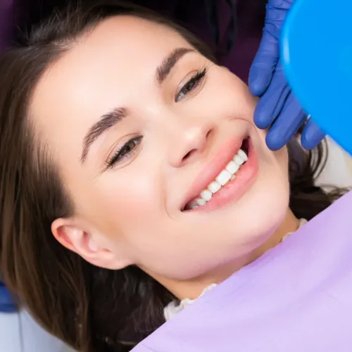 Smiling patient checking results after professional teeth whitening treatment in an Encino dental office.