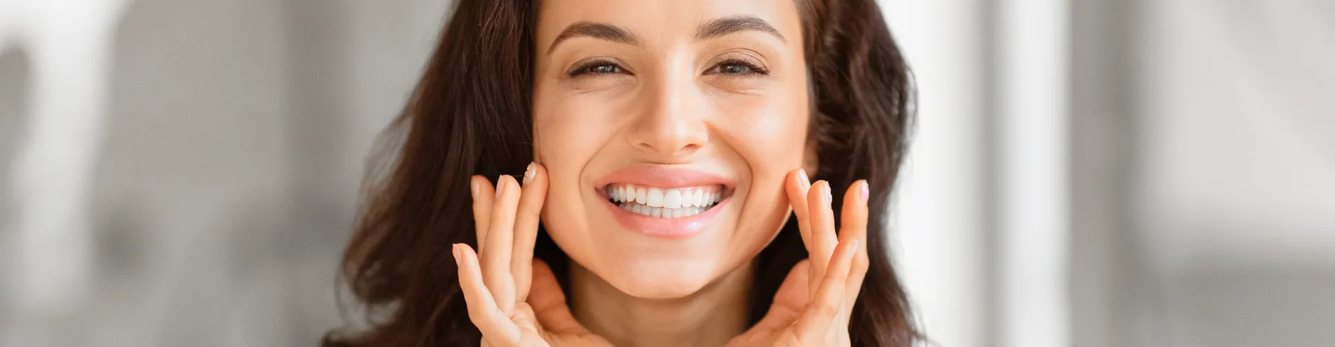 Woman framing her smile with her hands.