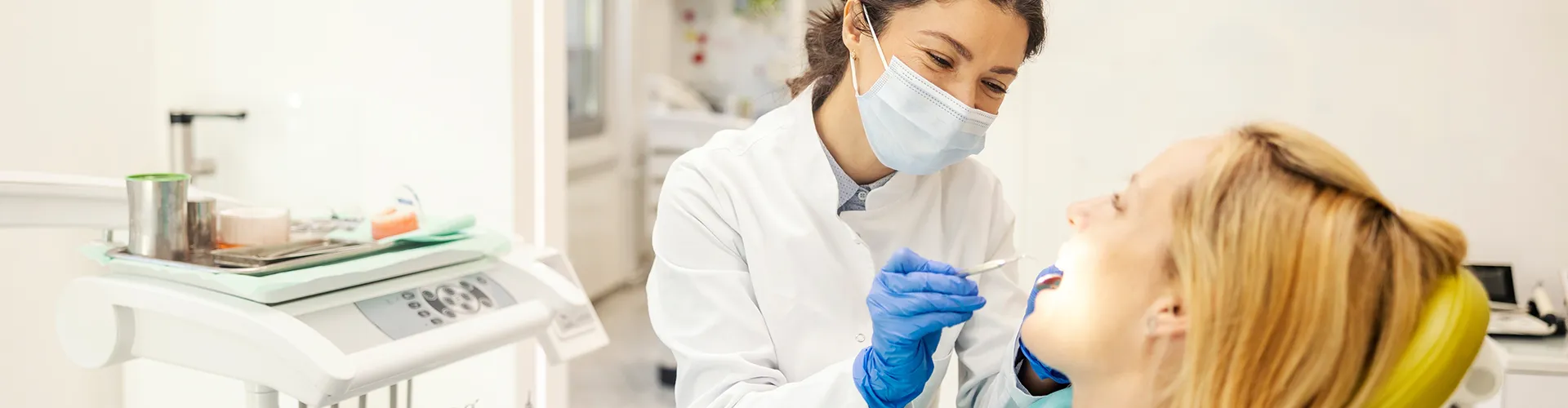 Dentist using dental tools in patient's mouth.