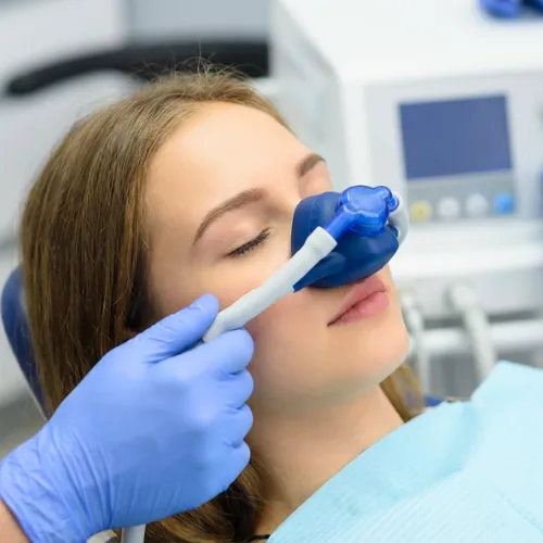 Gloved hands placing breathing mask over woman's nose.